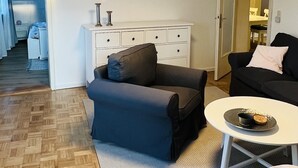 Un salón moderno con un sofá gris, una mesa de centro blanca y una alfombra estampada.
