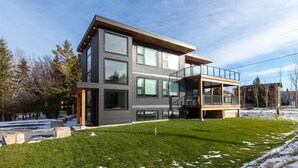 A modern two-story house with large windows, a balcony, and a well-maintained lawn. - High-Tech Mountain Luxury, Fitness, Hot Tub & BBQ (The Blue Mountains)