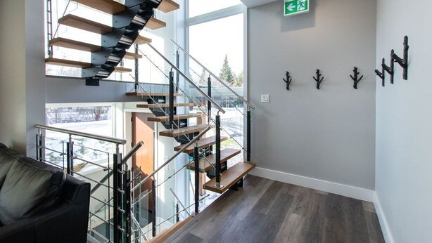 A modern interior with a spiral staircase, a glass railing, and a view of the outdoors. - High-Tech Mountain Luxury, Fitness, Hot Tub & BBQ (The Blue Mountains)