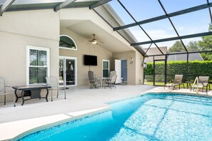 Relax by the pool surrounded by lush greenery and comfortable lounge seating.