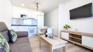 A modern apartment with a living room, kitchenette, and a dining area. - Delight Holiday Home (Playa del Inglés)