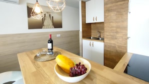 Una cocina moderna con armarios de madera, un lavamanos empotrado e iluminación colgante.
