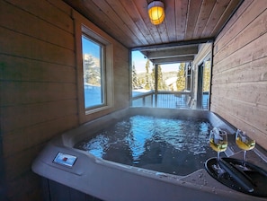 Relax in a hot tub surrounded by a serene snowy landscape and enjoy a peaceful retreat.