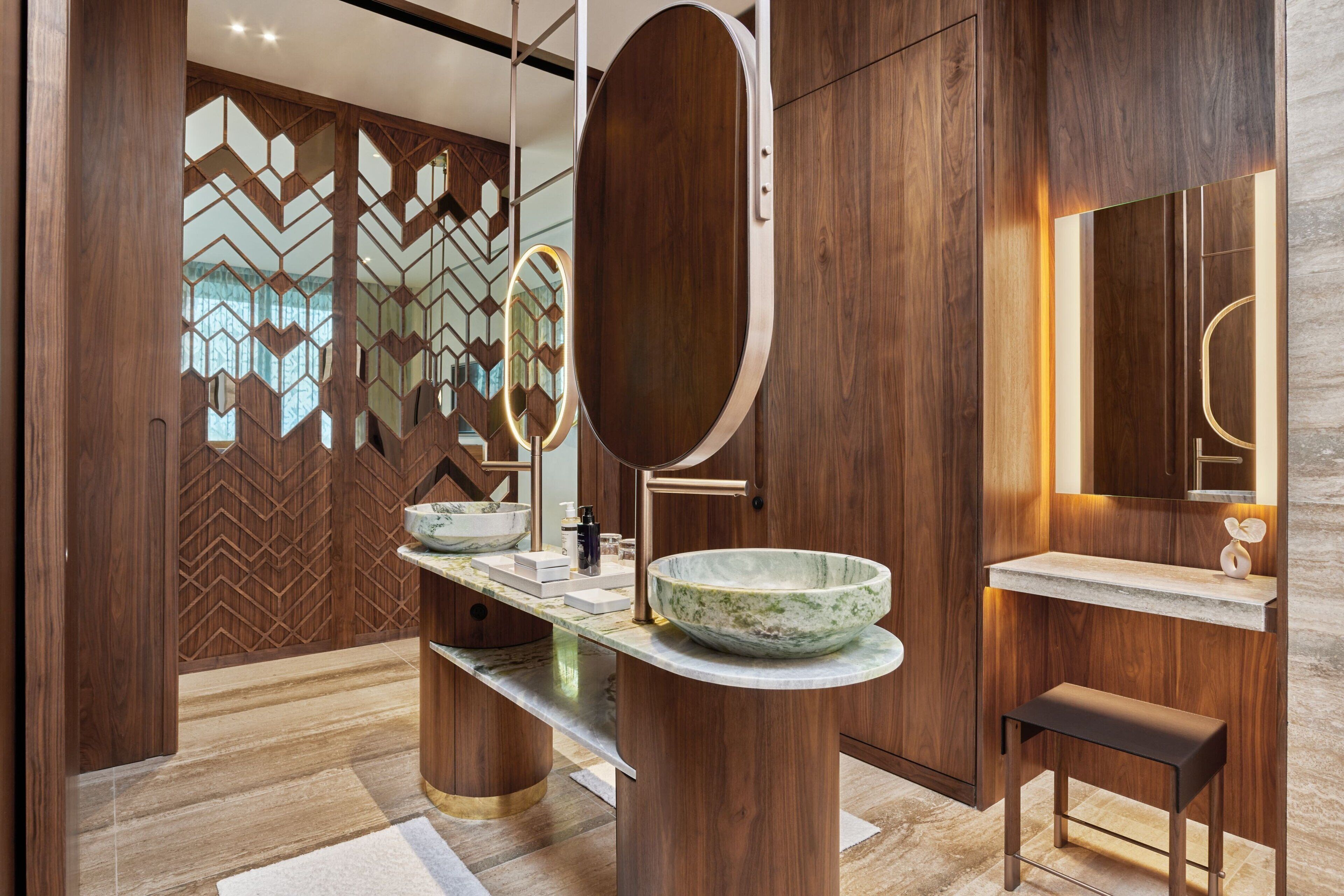 A modern bathroom with a wooden vanity, a large mirror, and a bowl sink.