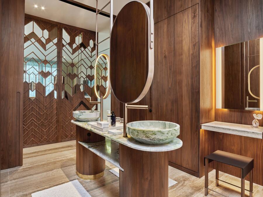 A modern bathroom with a wooden vanity, a large mirror, and a bowl sink.
