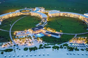 A large resort with multiple circular buildings, a central pool, and a beach area with sun loungers. - The St. Regis Kanai Resort, Riviera Maya (Playa del Carmen)