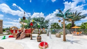 A water park with a pirate ship, palm trees, and a fountain.
