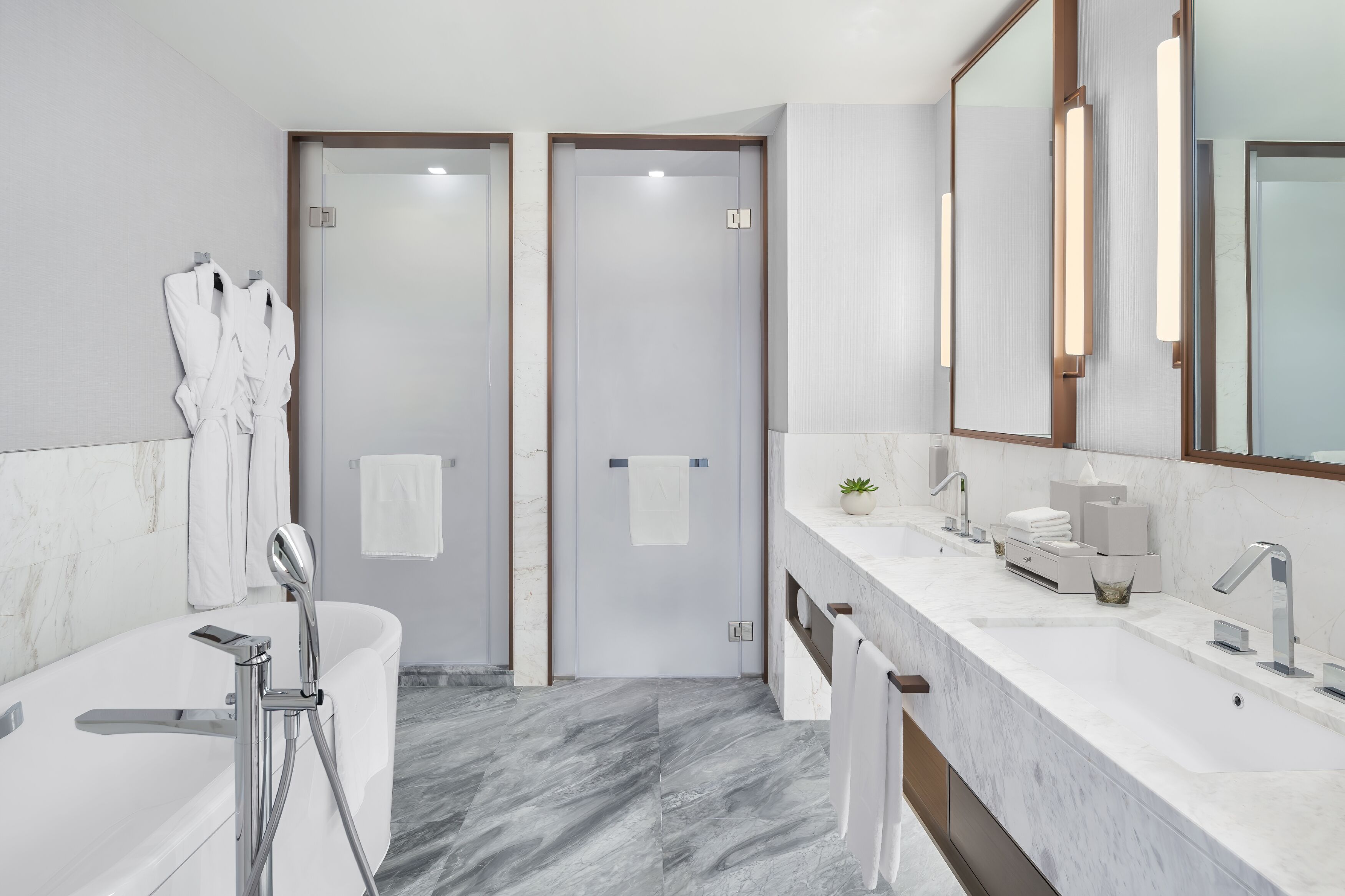 A modern bathroom with a bathtub, a large mirror, and a vanity with a sink.