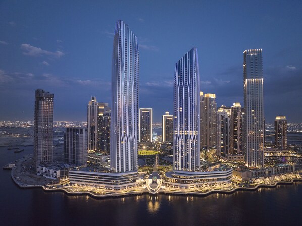 Un horizonte urbano con rascacielos, arquitectura moderna, dos imponentes edificios con diseños distintivos y un paseo marítimo.