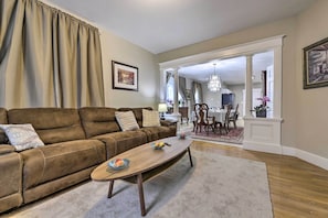 A living room with a brown leather sofa, a wooden coffee table, and a dining area in the background. - 2 Mi to Downtown: Springfield Apt w/ Balcony! (Springfield)