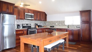 Una cucina moderna con mobili in legno, elettrodomestici in acciaio inossidabile e un'isola grande in legno.