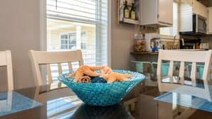 A dining table with a blue textured bowl containing starfish, white chairs, and a kitchen in the background. - 200 yards to private gated beach access! 3BR/2BA. Quiet location in Destin (Destin)