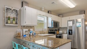 A kitchen with white cabinets, a granite countertop, a stainless steel refrigerator, and a built-in microwave. - 200 yards to private gated beach access! 3BR/2BA. Quiet location in Destin (Destin)