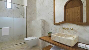 A bathroom with a shower, toilet, vanity with a sink, and a mirror.