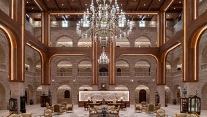 Un vaste hall d’entrée agrémenté d’un grand lustre, d’arcs en pierre et de sièges luxueux.