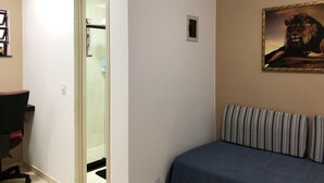 Un dormitorio con una cama, un escritorio y un cuadro de un león.