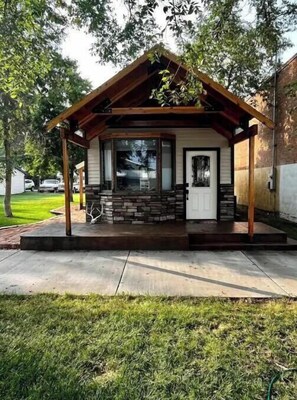 A house with a covered porch, stone steps, and a door with a window above it. - Little Blue Cabin (Fort Benton)