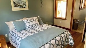 Una camera da letto con un letto, un quadro al muro e una finestra.