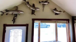 Una stanza con soffitto spiovente e pesci appesi.