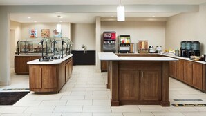 A modern kitchen with a central island, a refrigerator, a coffee machine, and a microwave. - 1 Bedroom | Free Wi-Fi, Pool, Free Breakfast (Durham)