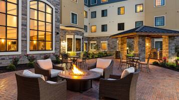 Evening courtyard with fire pit and outdoor lounge seating.