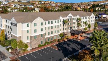 Elevated view of the hotel exterior with a covered entrance, parking lot, and landscaping.