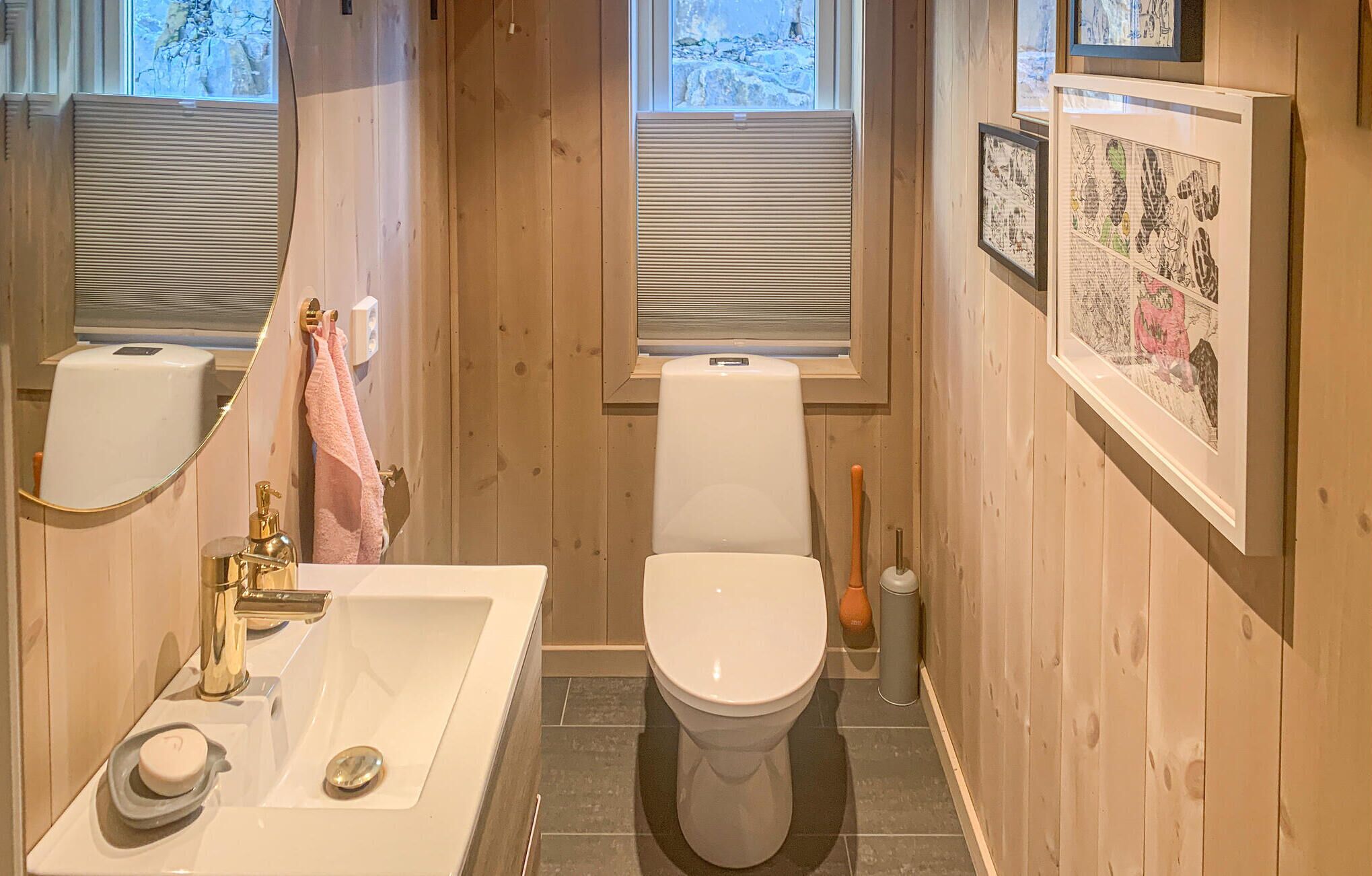 Ein Badezimmer mit Waschbecken, Toilette und Fensterläden.