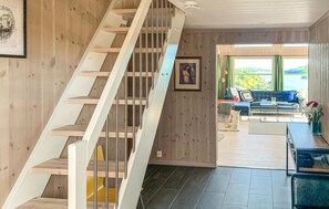 A modern interior with a wooden staircase, a living area with a sofa and a view of the outdoors. - Beautiful home in Risør with sauna (Risør)