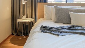 A hotel room with a bed, a nightstand with a lamp, and a view of the sea through large windows. - Flawless One Bedroom Old Town Scottsdale Condo (Scottsdale)
