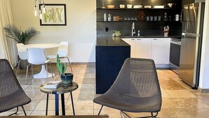 A modern living room with a dining area, a kitchen with dark countertops, and a large refrigerator. - Flawless One Bedroom Old Town Scottsdale Condo (Scottsdale)
