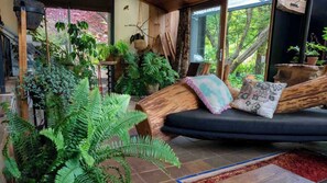 A cozy indoor space with a wooden bench, potted plants, and a staircase.