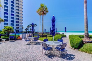 Relax on the oceanfront patio with comfortable outdoor seating and lush greenery.