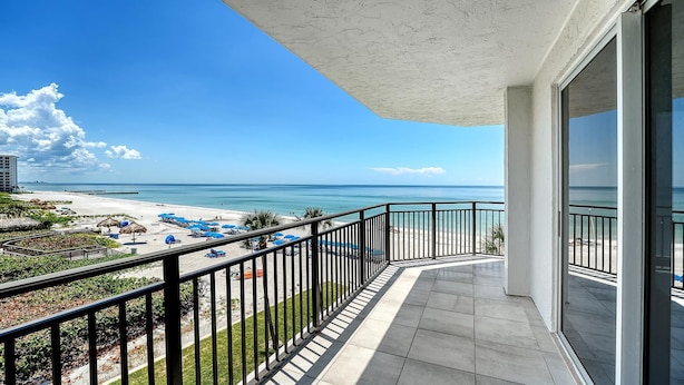 Un balcon avec vue sur une plage et l’océan.