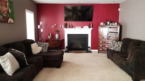A living room with two sofas, a fireplace, and a television mounted on the wall. - Harvest of tranquillity (Dover)