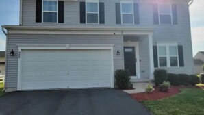 A two-story house with a garage, a front porch, and a driveway. - Harvest of tranquillity (Dover)