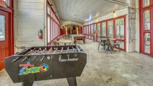 Une pièce équipée d’un baby-foot, d’une table de billard et d’une table de snooker.