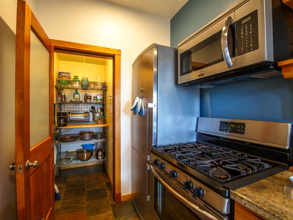 Cozinha compacta com micro-ondas, forno e fogão a gás integrados.