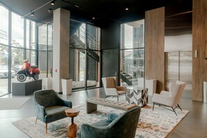 Un vestíbul modern amb seients, una taula de cafè i grans finestres que donen vista al carrer.