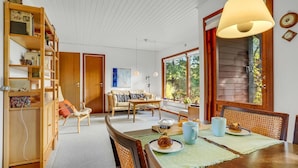 A cozy living room with a wooden dining table, chairs, and a bookshelf. - Amazing home in Rødby with WiFi (Rødby)