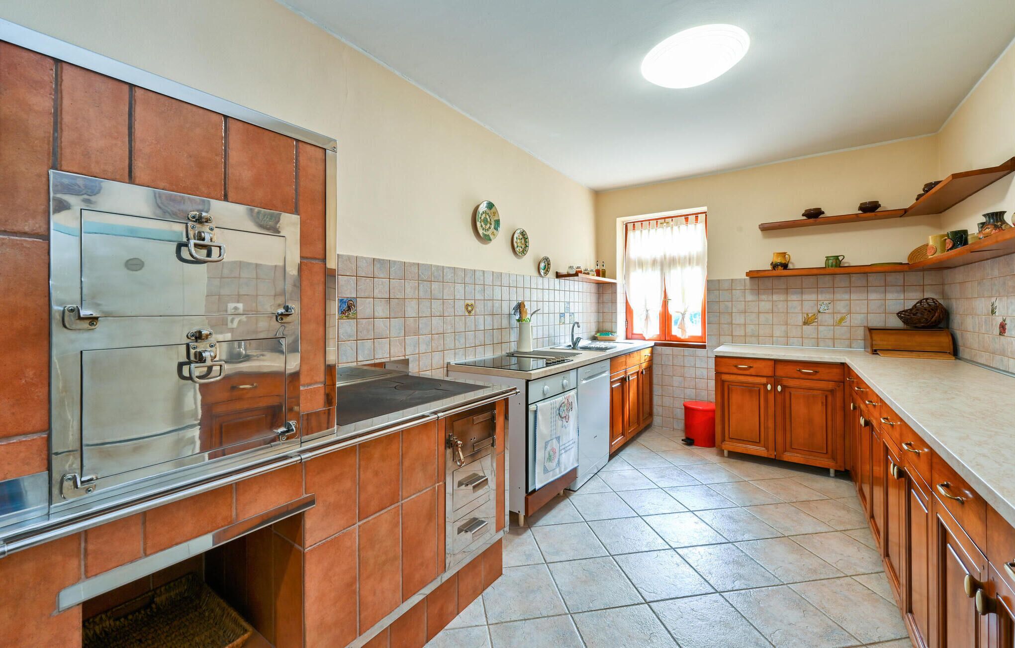 A kitchen with a built-in oven, a sink, and wooden cabinets.