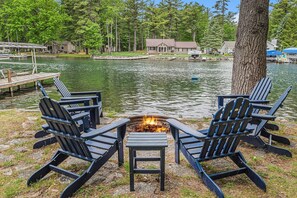 Un cadre idyllique au bord du lac, avec un foyer et des fauteuils Adirondack.
