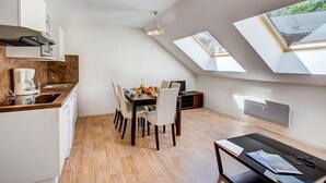 Eine moderne Küche mit Essbereich, Dachfenstern und Blick ins Freie.