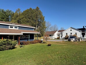 A residential area with houses, a lawn, and a parked car.