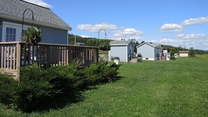 A residential area with a house, a deck, and a small shed. - Breezy Meadow Two 2 of 2,custom built cottage, under a mile from CDP (Milford)