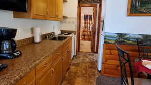 A kitchen with wooden cabinets, a coffee maker, a sink, and a stove. - Breezy Meadow Two 2 of 2,custom built cottage, under a mile from CDP (Milford)