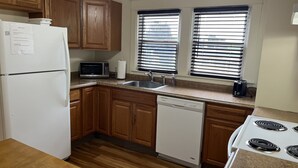 A kitchen with wooden cabinets, a white refrigerator, a microwave, a dishwasher, a stove, and a sink. - City Fox 1, 1 of 4, recent renovation in Oneonta, Convenient to All Star Village (Oneonta)