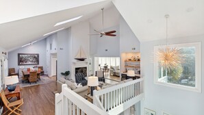 A spacious loft with high ceilings, a dining area, a living room with a fireplace, and a balcony with a view of the outdoors. - Across street from beach, Renovated, Wild Dunes - 7 Fairway Oaks (Isle Of Palms)