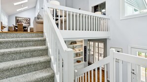 A staircase with white railings leading to a second-floor landing. - Across street from beach, Renovated, Wild Dunes - 7 Fairway Oaks (Isle Of Palms)