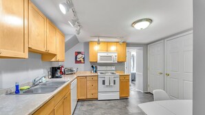 Una cocina compacta con armarios de madera, microondas, estufa y lavabo.