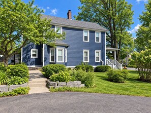 A two-story house with a front porch, a chimney, and a well-maintained lawn. - Diamond Dreams, Very close to Dreams Park, Recent update, fire pit, large yard (Cooperstown)